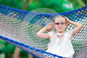Adorable little girl on summer vacation relaxing in hammock
