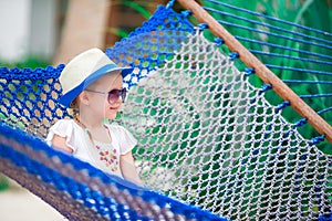 Adorable little girl on summer vacation relaxing in hammock