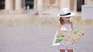 Adorable little girl with touristic map in St. Peter's Basilica square, Italy. Happy toodler kid enjoy italian vacation