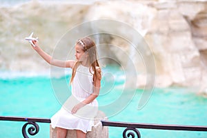 Adorable little girl with toy airplane background Trevi Fountain, Rome, Italy. Happy toodler kid enjoy italian vacation