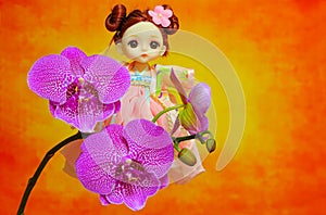 Adorable little girl toy with pink phalaenopsis orchids