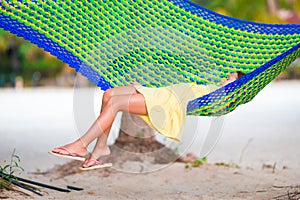 Adorable little girl on tropical vacation relaxing in hammock