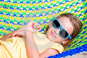 Adorable little girl on tropical vacation relaxing in hammock