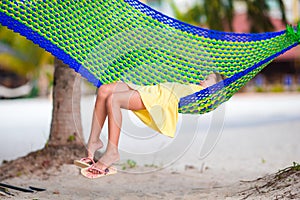Adorable little girl on tropical vacation relaxing in hammock