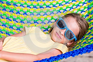 Adorable little girl on tropical vacation relaxing in hammock