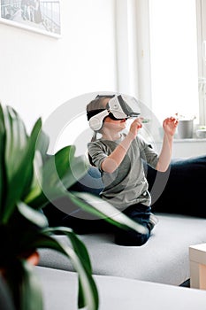 Adorable little girl using VR glasses to play a game