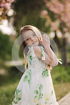 Adorable little girl walk barefoot in the park. Happy kid spent time on the fresh air. End of quarantine