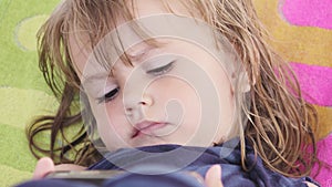 Adorable little girl watching smartphone