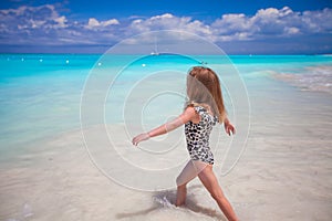 Adorable little girl at white beach during summer