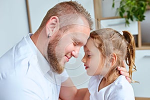 Adorable little girl in white dress hugging loving father