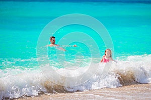 Happy little girls swimming in the sea during summer vacation