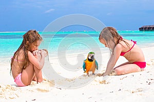 Adorable little girls with big colorful parrot