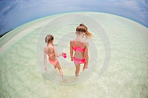 Adorable little girls have fun on the beach