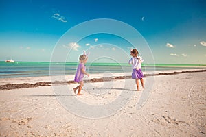 Adorable little girls have fun on white beach