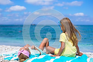 Adorable little girls have fun on white beach