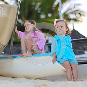 Adorable little girls have fun on white beach