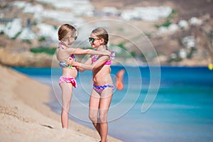 Adorable little girls having fun during beach vacation. Two kids together on greek vacation