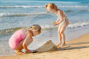 Adorable little girls playing at the seashore