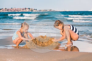 Adorable little girls playing at the seashore