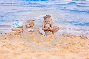 Adorable little girls playing at the seashore