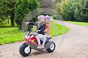 Adorable little girls riding on kid's bike in the