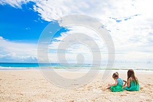 Adorable little girls during summer vacation. Kids with beach toys on the white beach