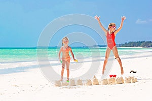 Adorable little girls during summer vacation. Kids playing with beach toys on the white beach