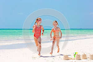 Adorable little girls during summer vacation. Kids playing with beach toys on the white beach