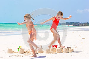 Adorable little girls during summer vacation. Kids playing with beach toys on the white beach