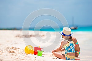 Adorable little girls during summer vacation. Kids playing with beach toys on the white beach