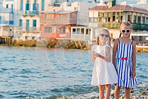 Adorable little girls on vacation on Mykonos island, Greece.