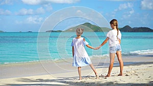 Adorable little girls walking on the beach and having fun together