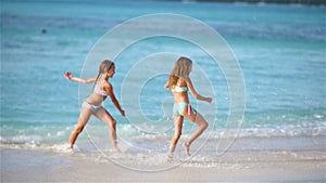 Adorable little girls walking on the beach and having fun together