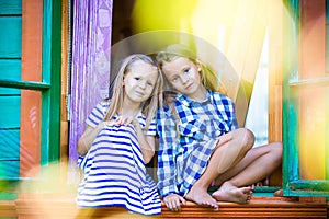 Adorable little girls in the window of rural house