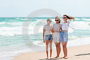 Adorable little girls and young mother on tropical white beach