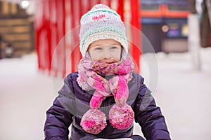 Adorable little happy girl skating on the ice-rink