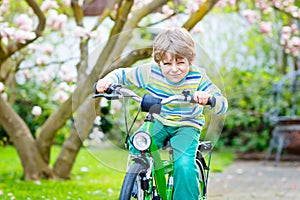 Adorable little kid boy driving his first bike or laufrad