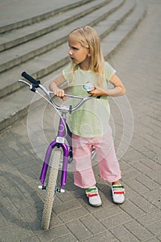 adorable little kid with ice cream and bicycle standing