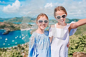 Adorable little kids enjoying the view of picturesque English Harbour at Antigua in caribbean sea