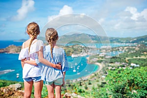 Adorable little kids enjoying the view of picturesque English Harbour at Antigua in caribbean sea