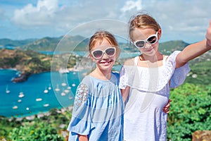 Adorable little kids enjoying the view of picturesque English Harbour at Antigua in caribbean sea