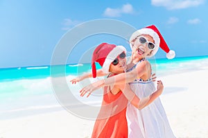 Adorable little kids in Santa hat during Christmas beach vacation. New Year on the beach