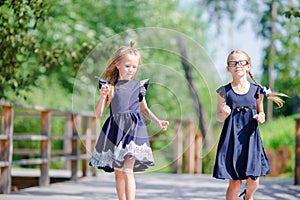 Adorable little school girls outdoors in warm september day. Back to school.