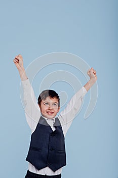 Adorable little schoolboy celebrating victory in studio