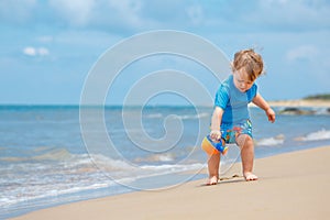 Adorable little toddler girl playing on sand beach