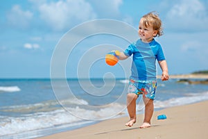 Adorable little toddler girl playing on sand beach