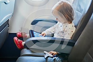 Adorable little toddler girl traveling by plane