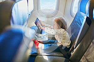 Adorable little toddler girl traveling by plane