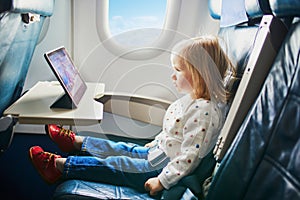 Adorable little toddler girl traveling by plane
