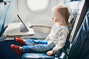 Adorable little toddler girl traveling by plane